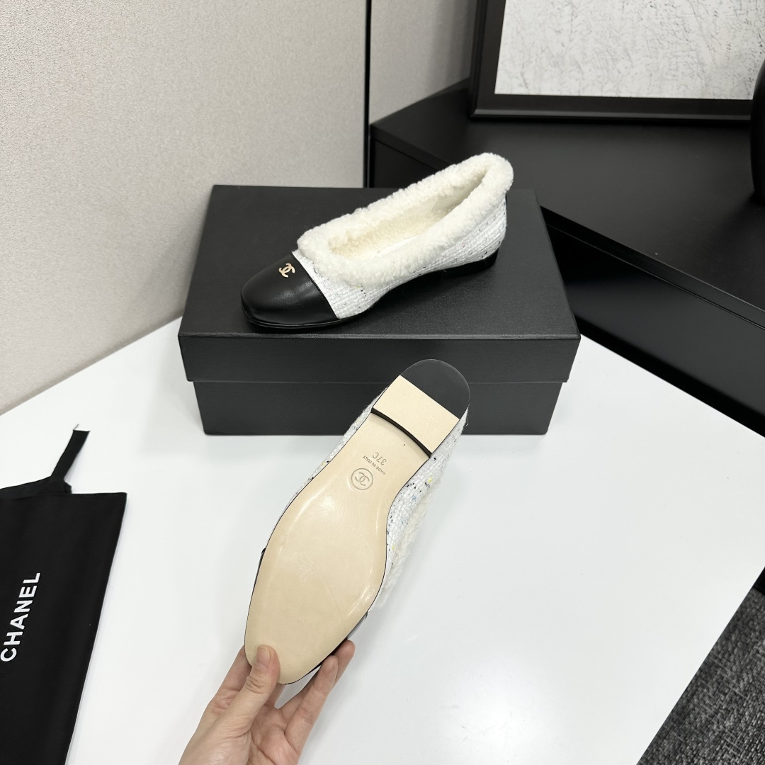 Luxury Chanel white tweed ballet flats with black leather toe caps and white faux fur lining displayed on a black designer box. - Hình 5