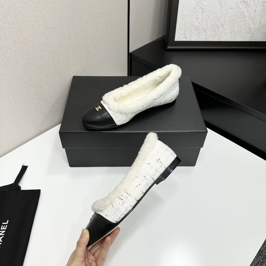 Luxury Chanel white tweed ballet flats with black leather toe caps and white faux fur lining displayed on a black designer box. - Hình 4