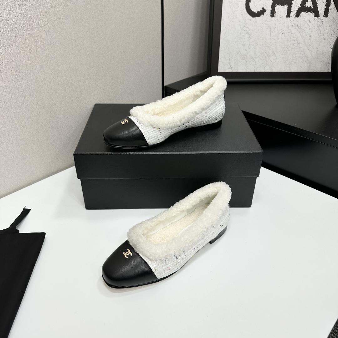 Luxury Chanel white tweed ballet flats with black leather toe caps and white faux fur lining displayed on a black designer box. - Hình 3