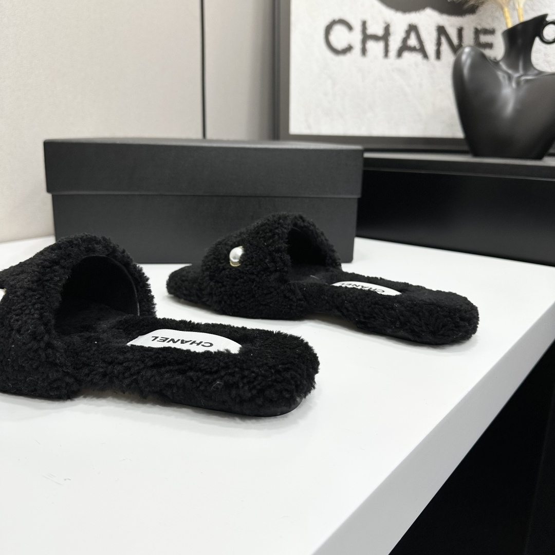 Luxurious black Chanel shearling slides featuring a pearl and gold CC logo displayed on a designer box. - Hình 9