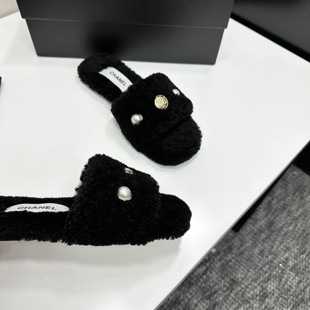 Luxurious black Chanel shearling slides featuring a pearl and gold CC logo displayed on a designer box. - Hình 8