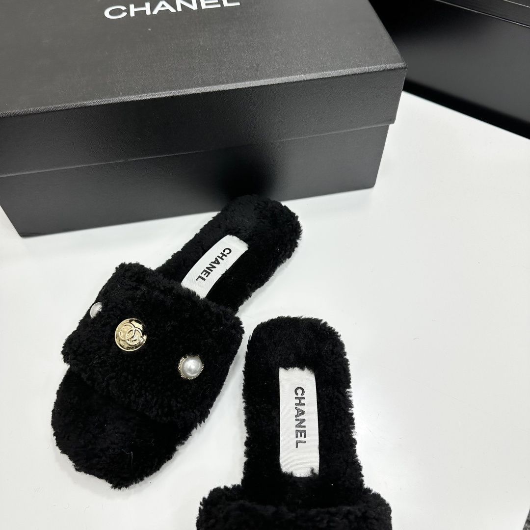 Luxurious black Chanel shearling slides featuring a pearl and gold CC logo displayed on a designer box. - Hình 6