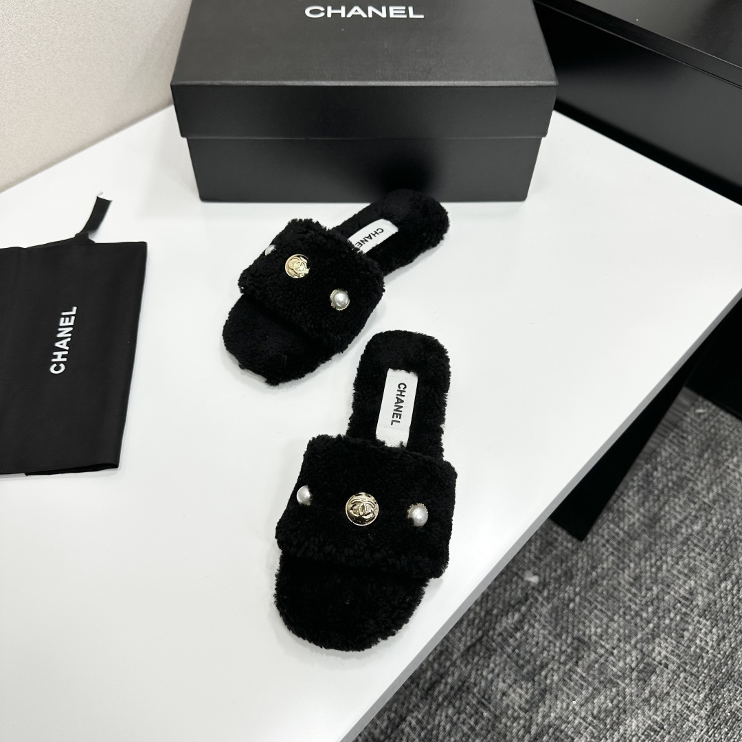 Luxurious black Chanel shearling slides featuring a pearl and gold CC logo displayed on a designer box. - Hình 5