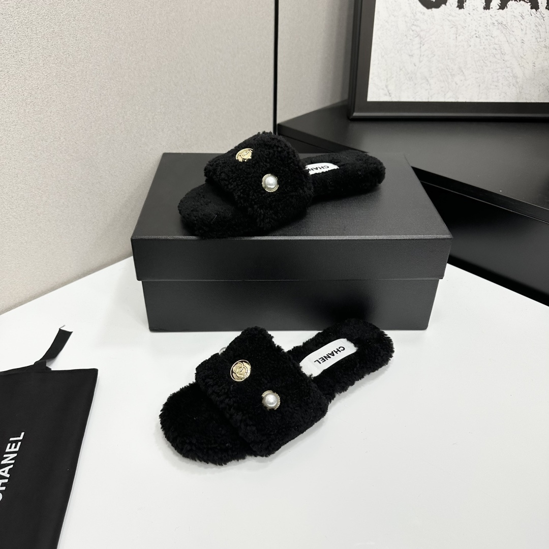 Luxurious black Chanel shearling slides featuring a pearl and gold CC logo displayed on a designer box. - Hình 2
