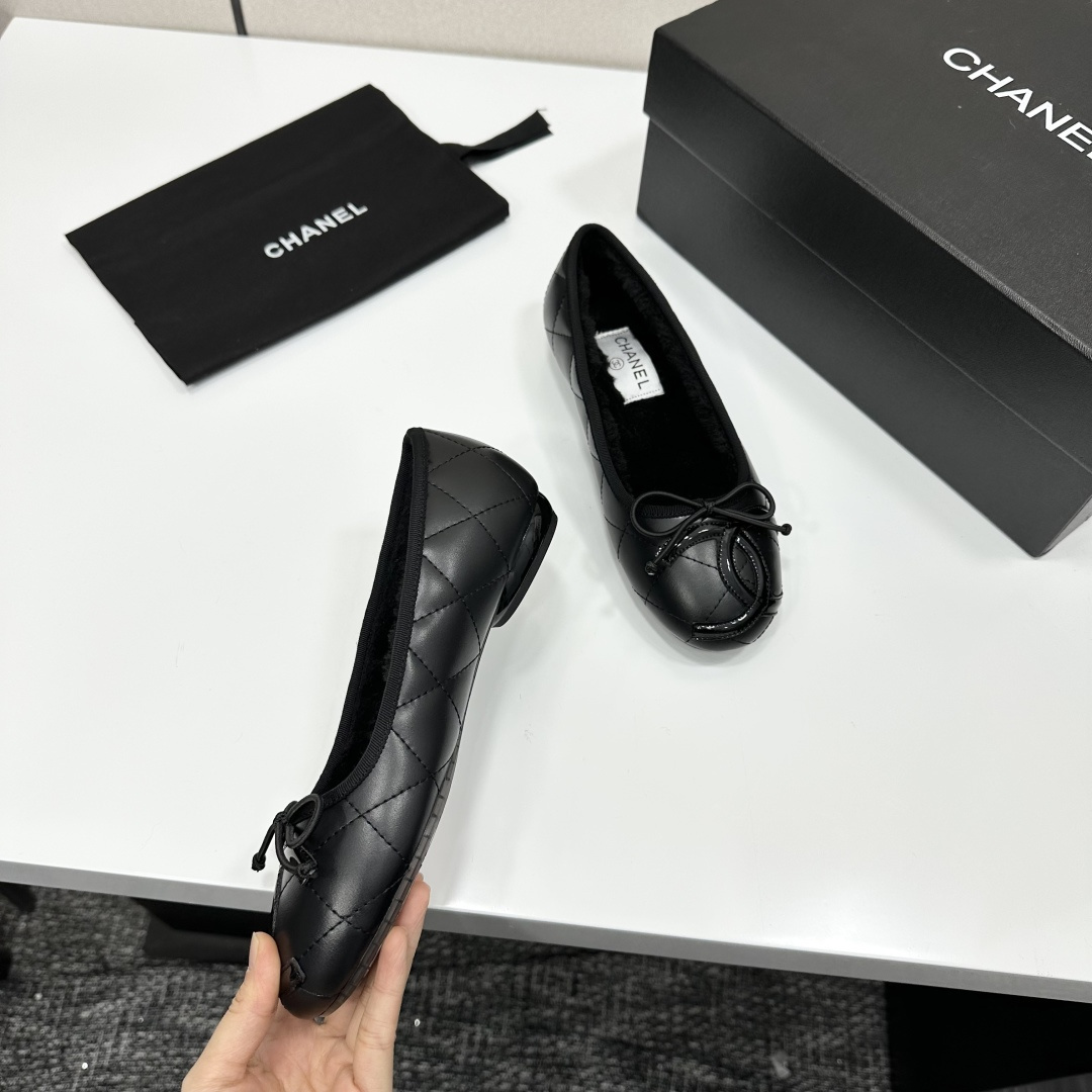Pair of Chanel black quilted leather ballet flats with bow detail and warm interior lining on a black designer box. - Hình 8