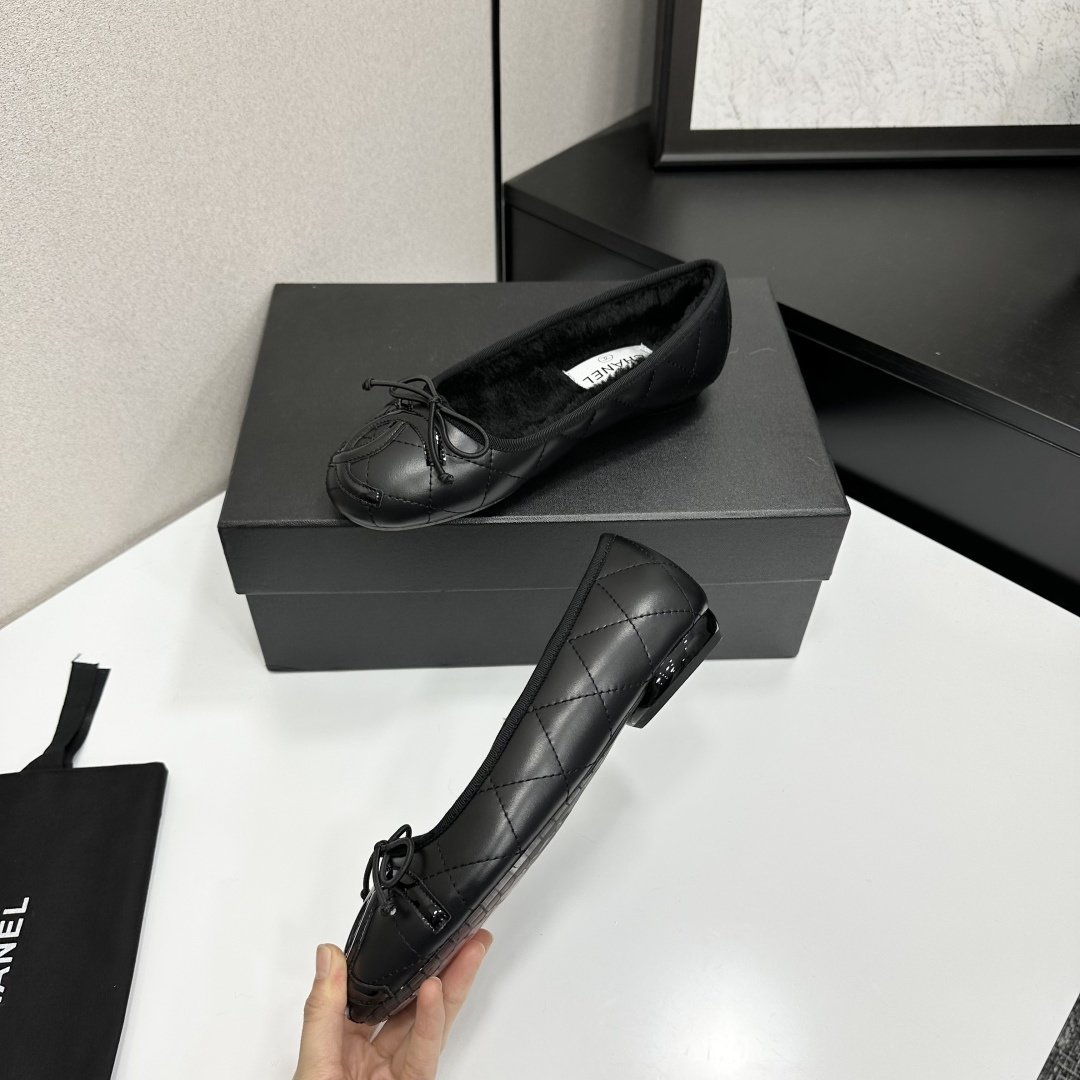 Pair of Chanel black quilted leather ballet flats with bow detail and warm interior lining on a black designer box. - Hình 3