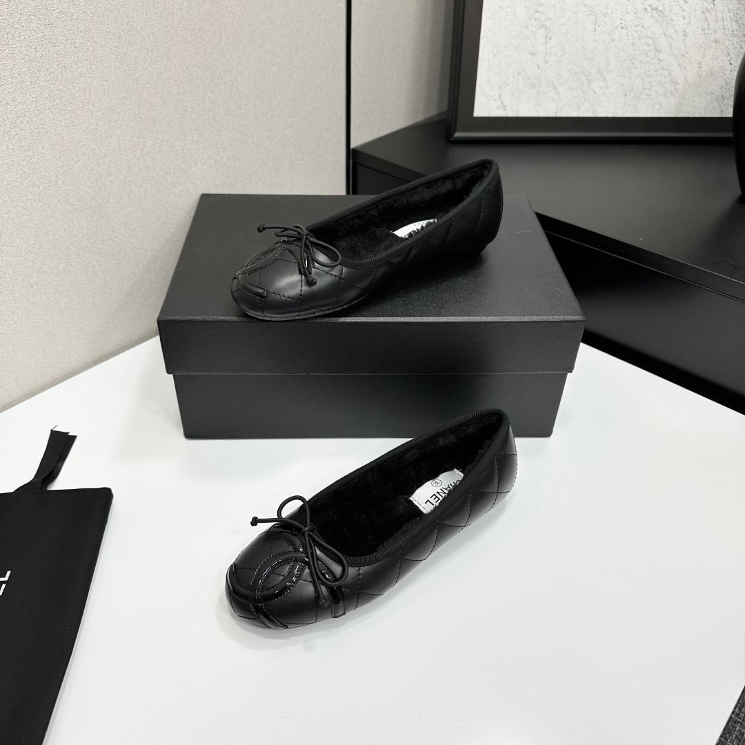 Pair of Chanel black quilted leather ballet flats with bow detail and warm interior lining on a black designer box. - Hình 2