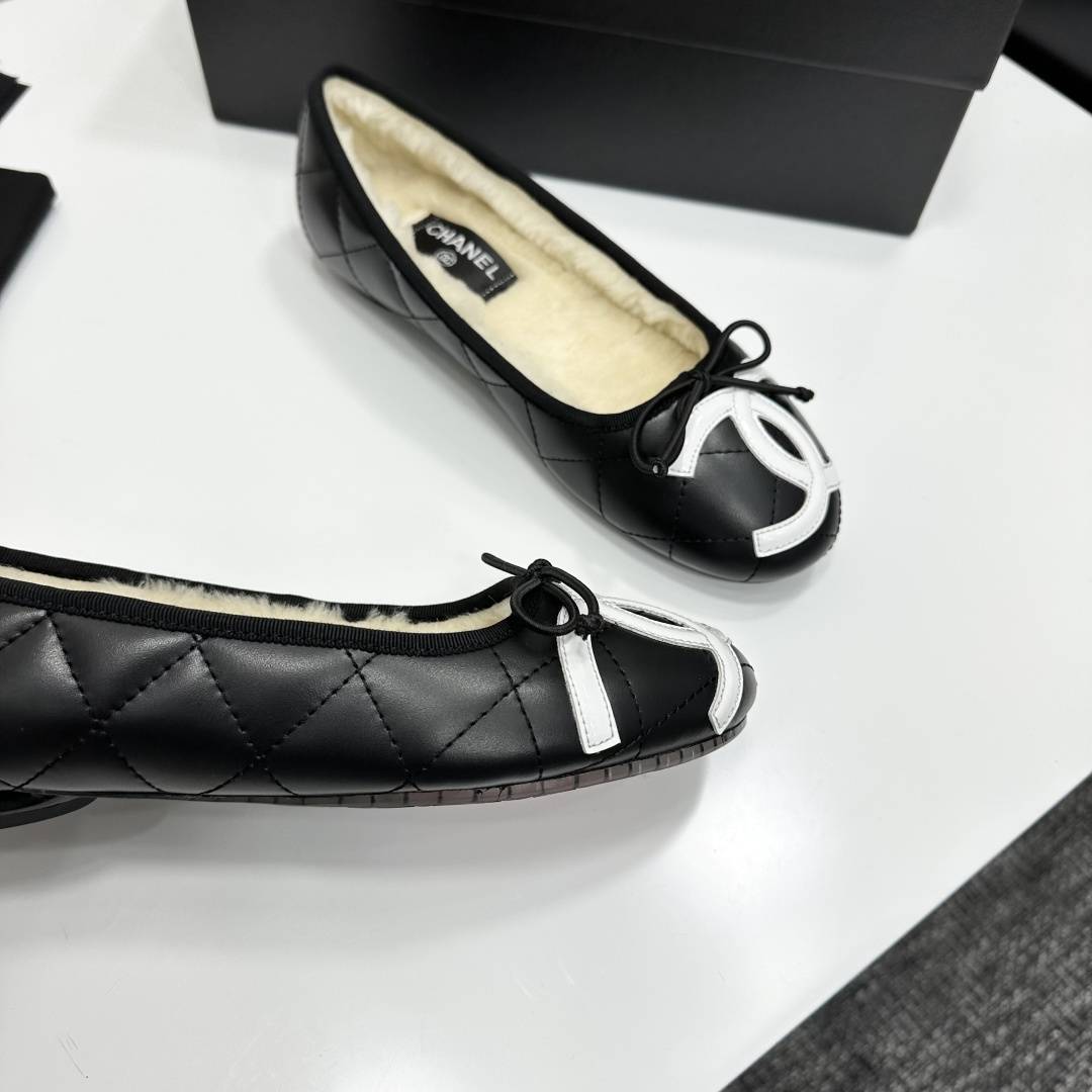 Black quilted Chanel ballet flats with white CC logo and cream shearling lining displayed on a black box. - Hình 9
