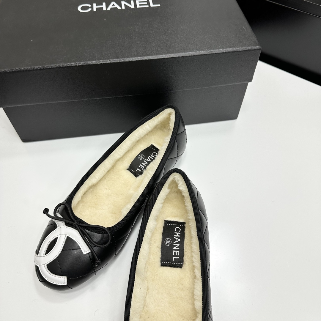 Black quilted Chanel ballet flats with white CC logo and cream shearling lining displayed on a black box. - Hình 6