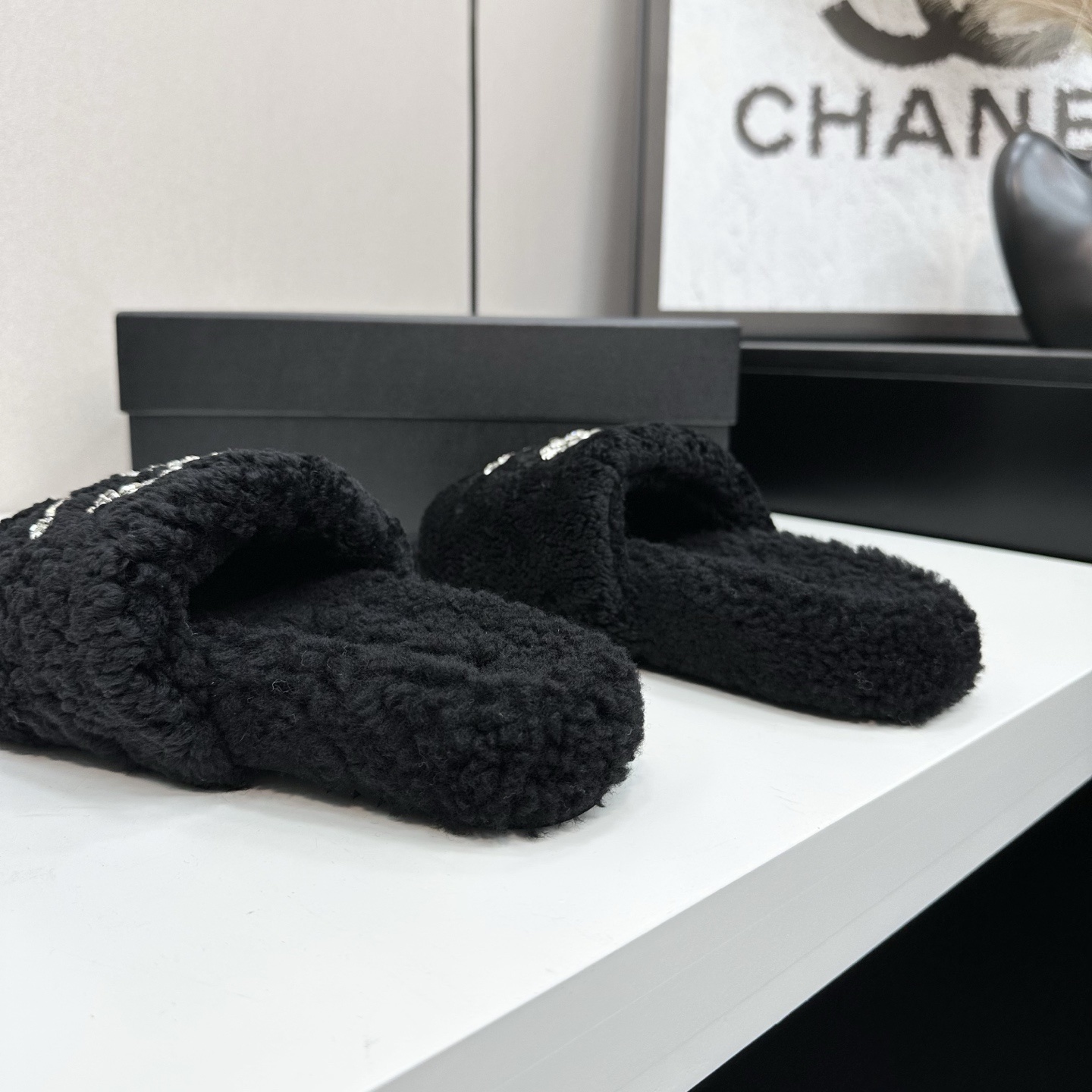 Pair of black fluffy faux fur slides featuring a sparkling crystal double C logo on a black display box. - Hình 9