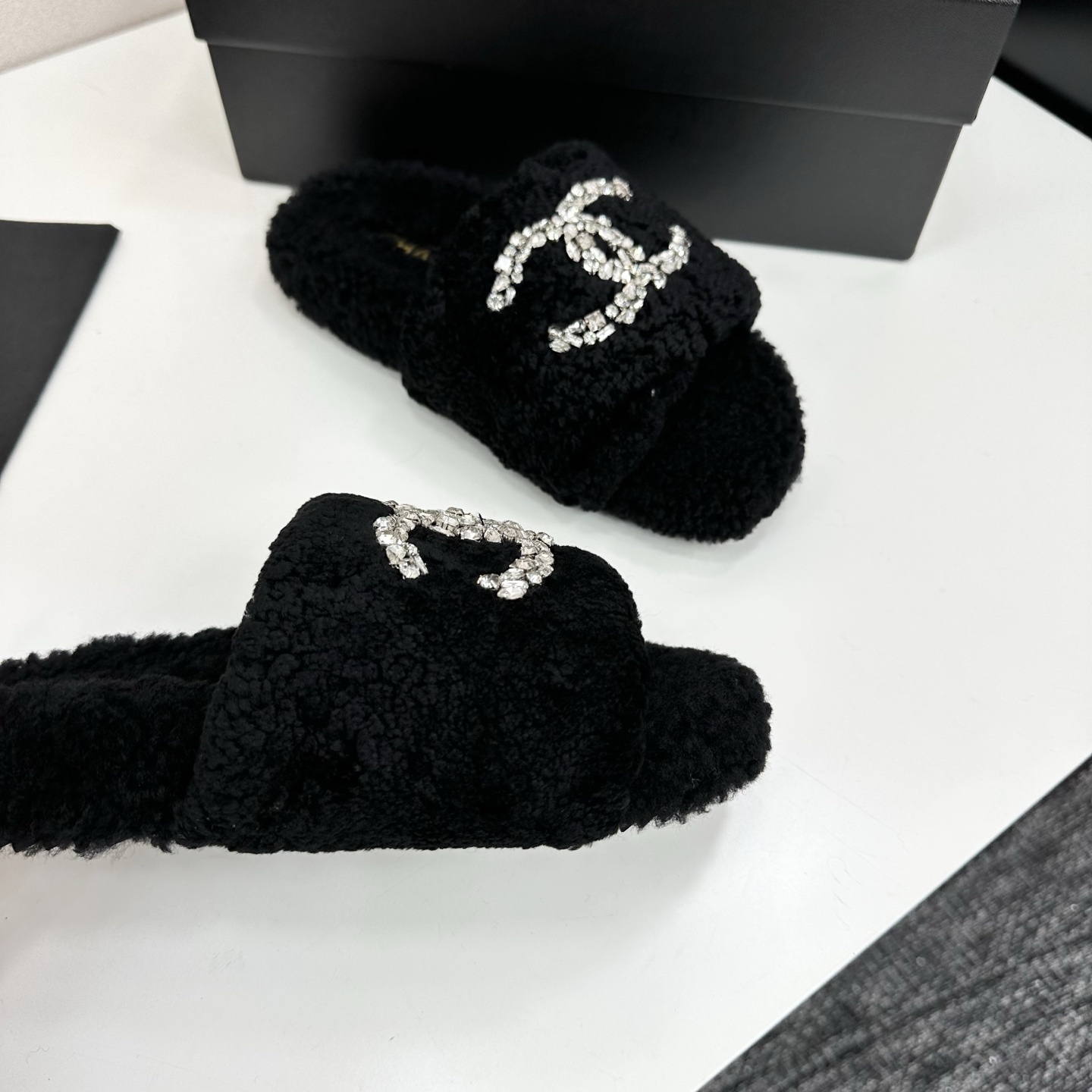 Pair of black fluffy faux fur slides featuring a sparkling crystal double C logo on a black display box. - Hình 8