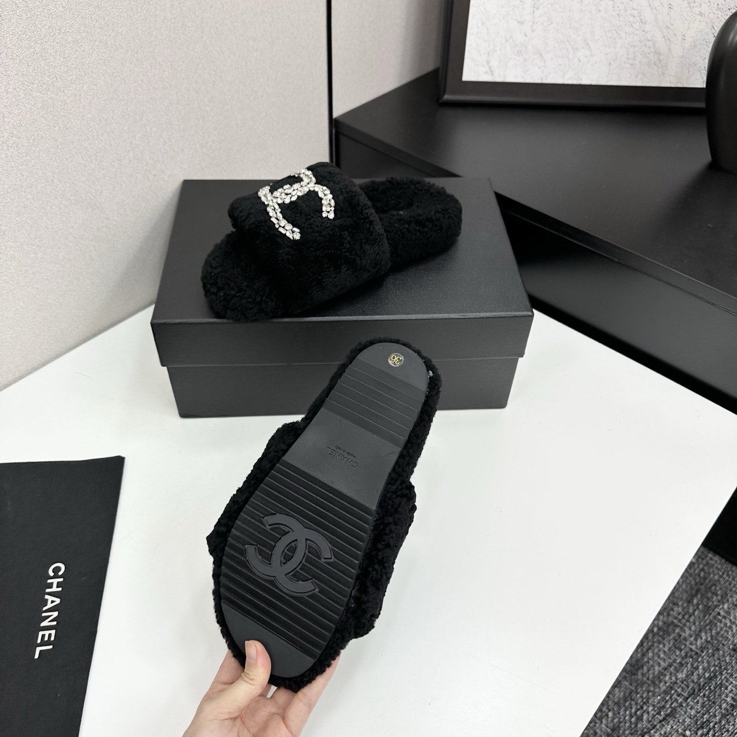 Pair of black fluffy faux fur slides featuring a sparkling crystal double C logo on a black display box. - Hình 4