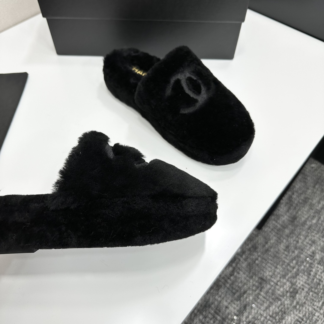 Luxury black Chanel faux fur slippers with interlocking CC logo displayed on a black product box - Hình 8