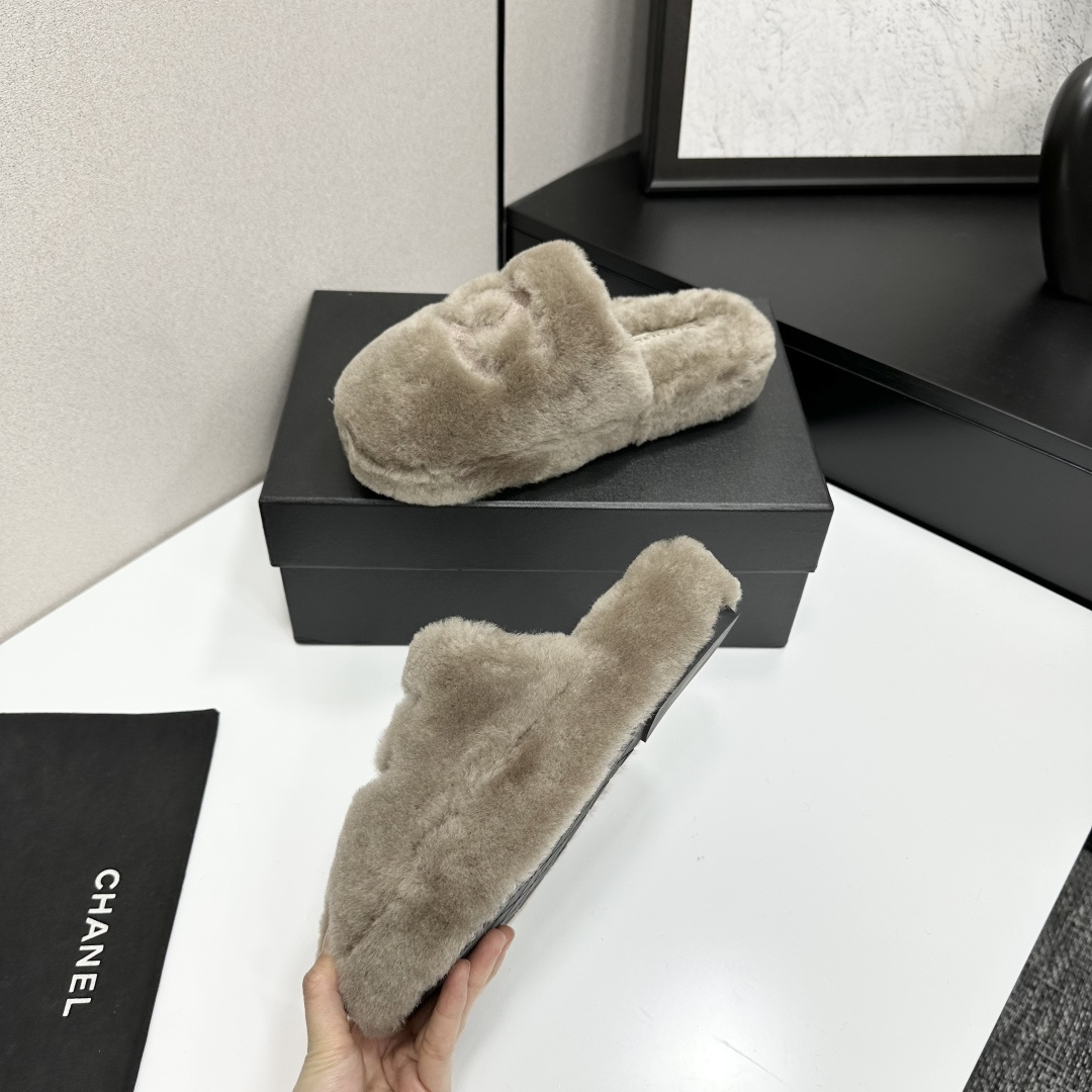 A pair of grey Chanel-inspired plush faux fur platform slippers displayed on a black designer box. - Hình 3
