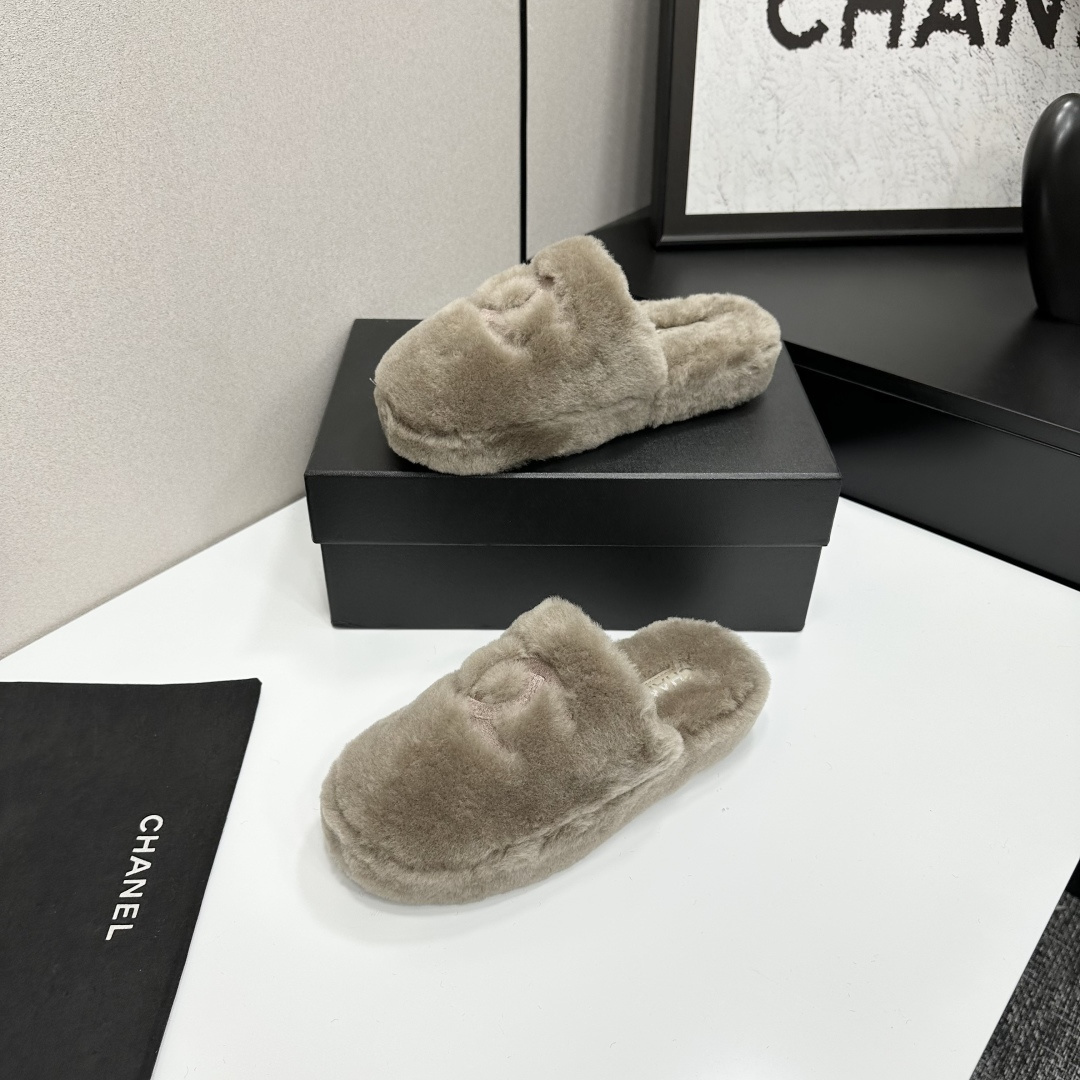 A pair of grey Chanel-inspired plush faux fur platform slippers displayed on a black designer box. - Hình 2