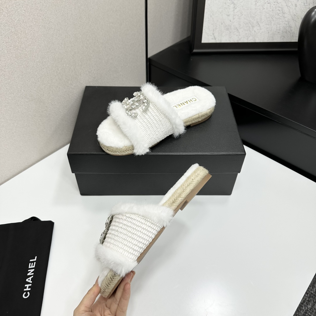 Pair of luxury white faux fur slides with crystal logo embellishment and espadrille soles on a black gift box - Hình 3