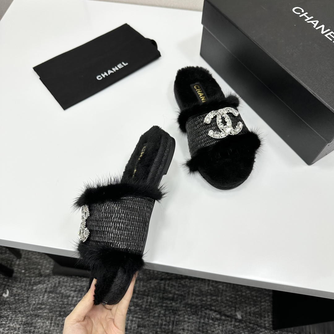 Luxury black fur slippers with a woven strap and a large crystal-encrusted interlocking logo displayed on a black box. - Hình 8