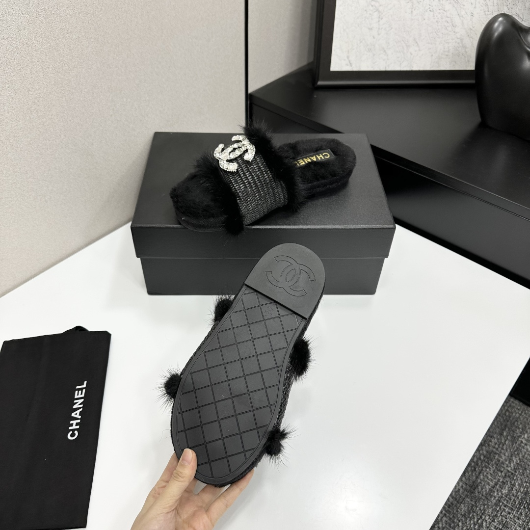 Luxury black fur slippers with a woven strap and a large crystal-encrusted interlocking logo displayed on a black box. - Hình 4