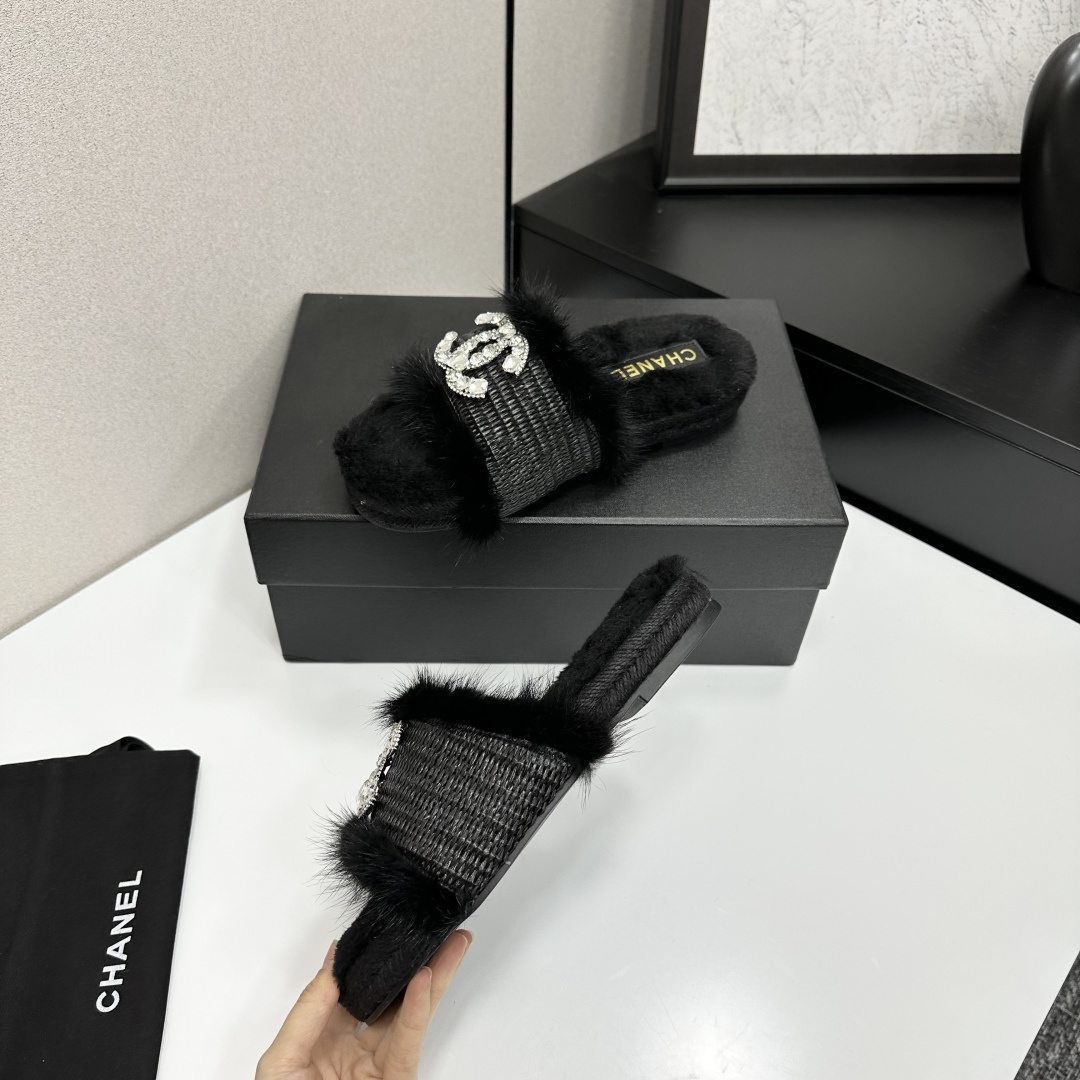Luxury black fur slippers with a woven strap and a large crystal-encrusted interlocking logo displayed on a black box. - Hình 3