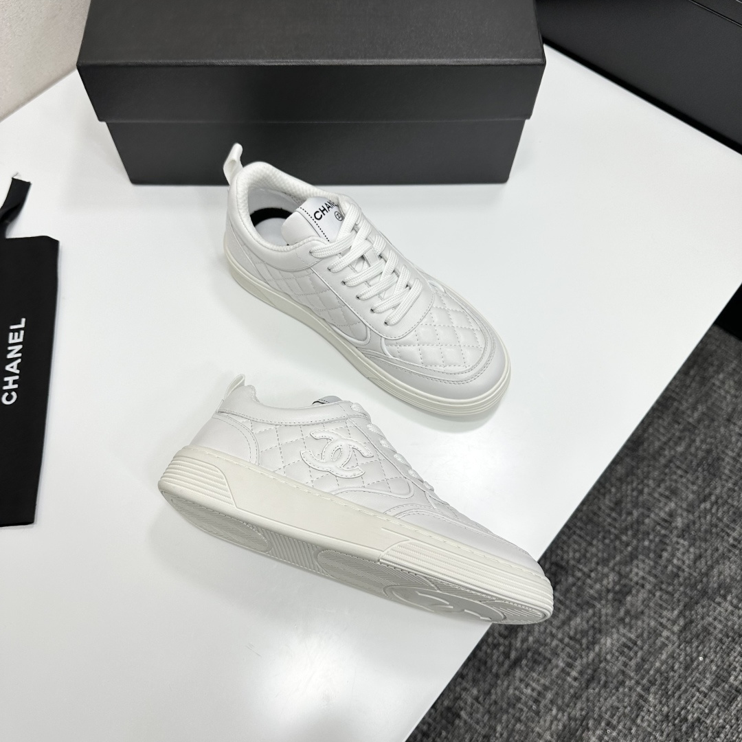 Side view of white Chanel quilted leather sneakers with interlocking CC logo and platform sole on a black box - Hình 11