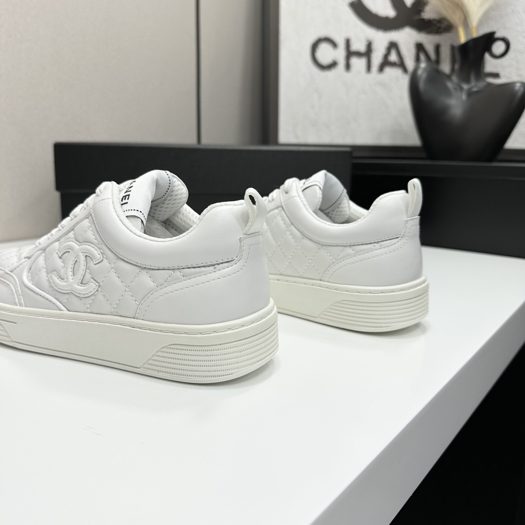 Side view of white Chanel quilted leather sneakers with interlocking CC logo and platform sole on a black box - Hình 10