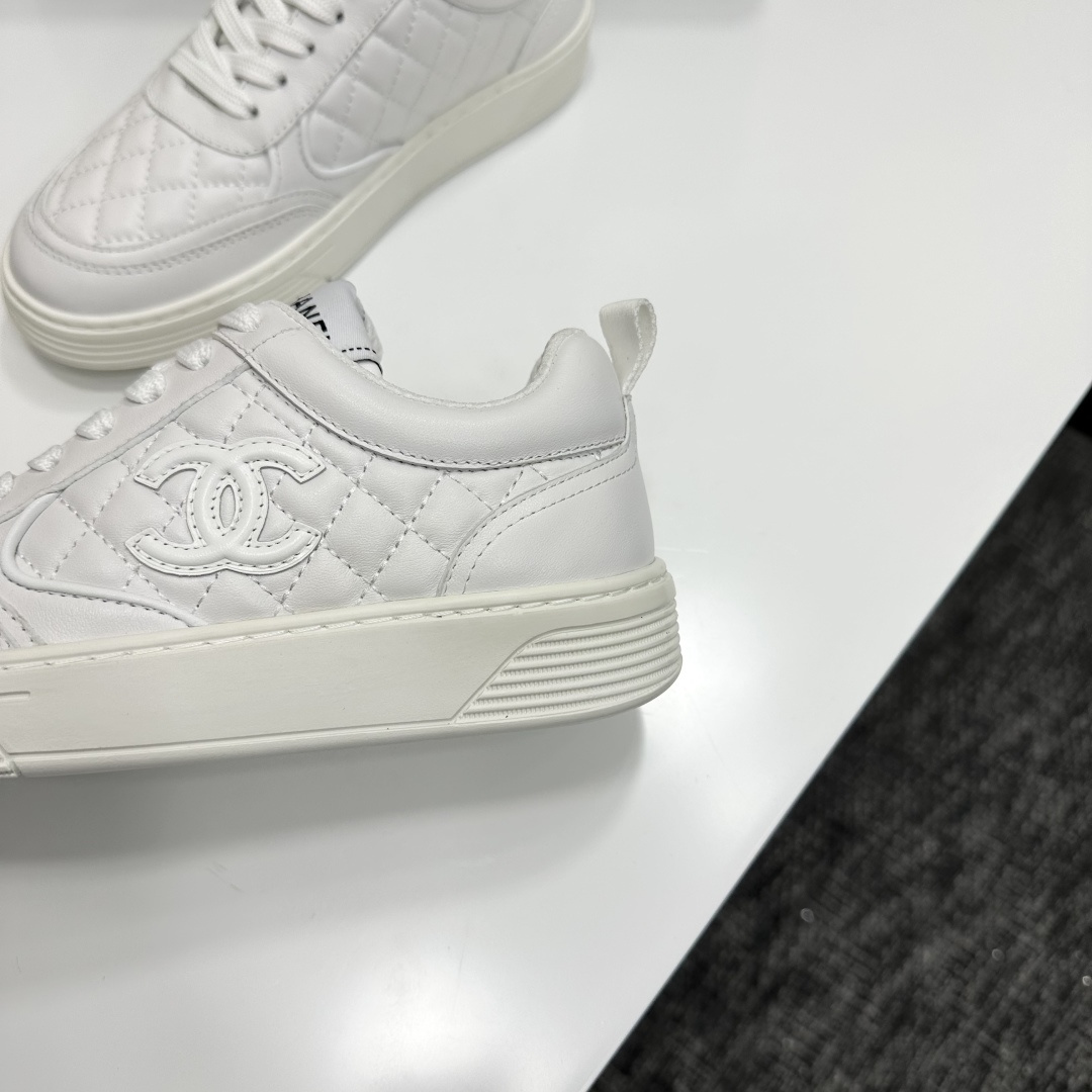 Side view of white Chanel quilted leather sneakers with interlocking CC logo and platform sole on a black box - Hình 9