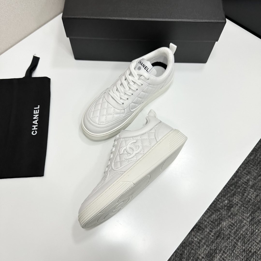 Side view of white Chanel quilted leather sneakers with interlocking CC logo and platform sole on a black box - Hình 8