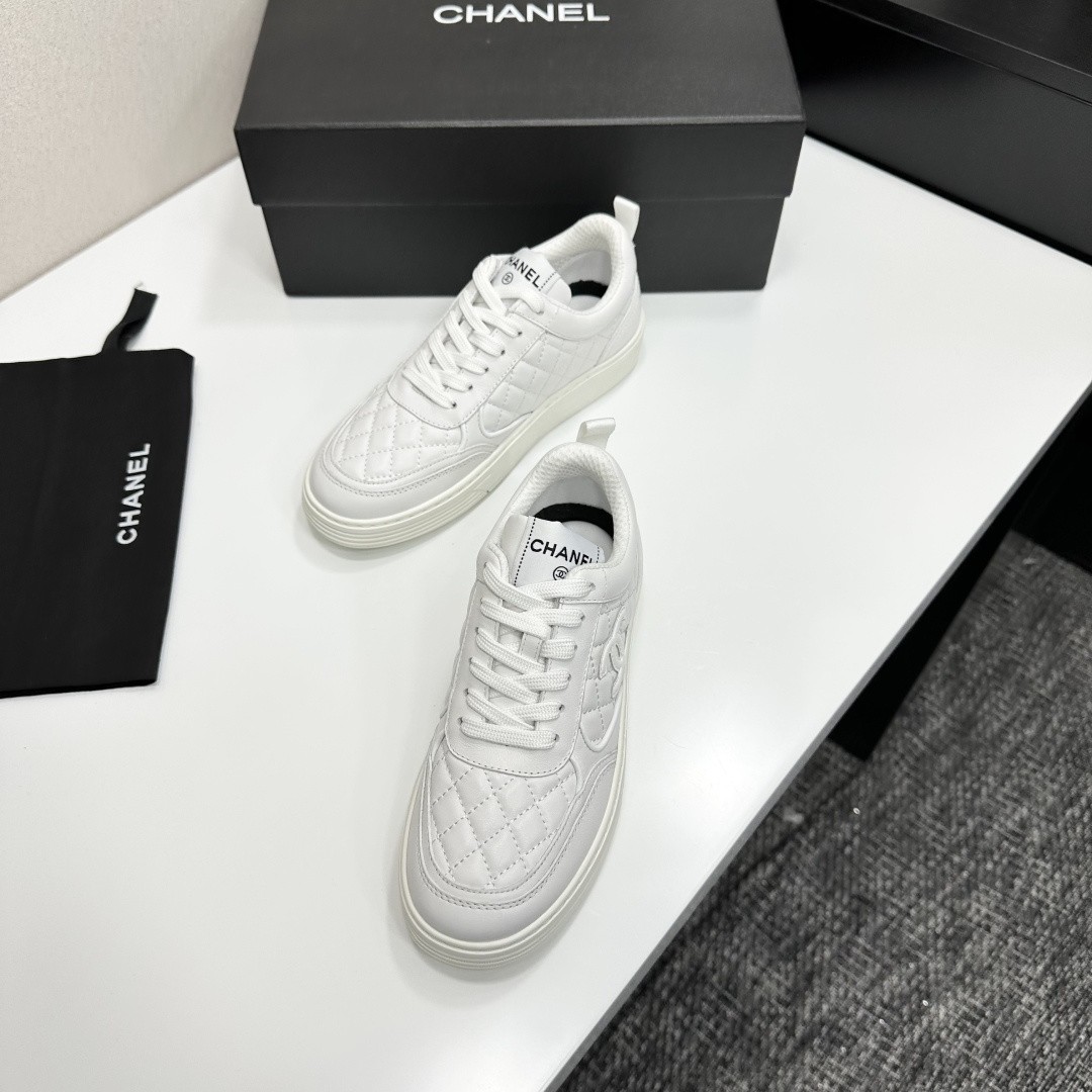 Side view of white Chanel quilted leather sneakers with interlocking CC logo and platform sole on a black box - Hình 7