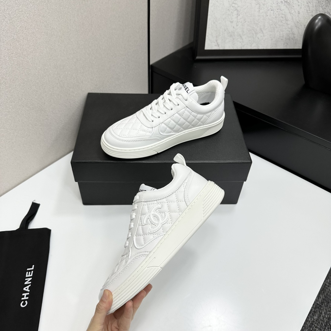 Side view of white Chanel quilted leather sneakers with interlocking CC logo and platform sole on a black box - Hình 5