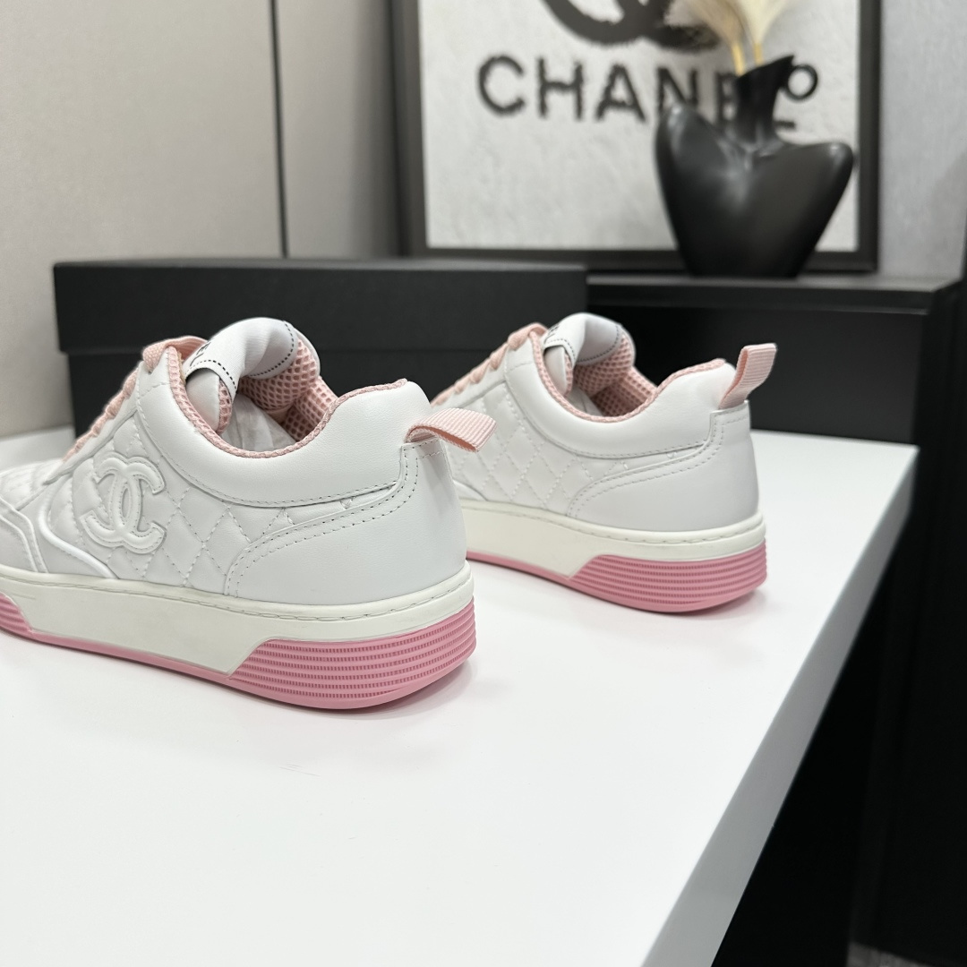 A pair of Chanel white quilted leather sneakers with pink laces and pink outsoles displayed on a black box. - Hình 10