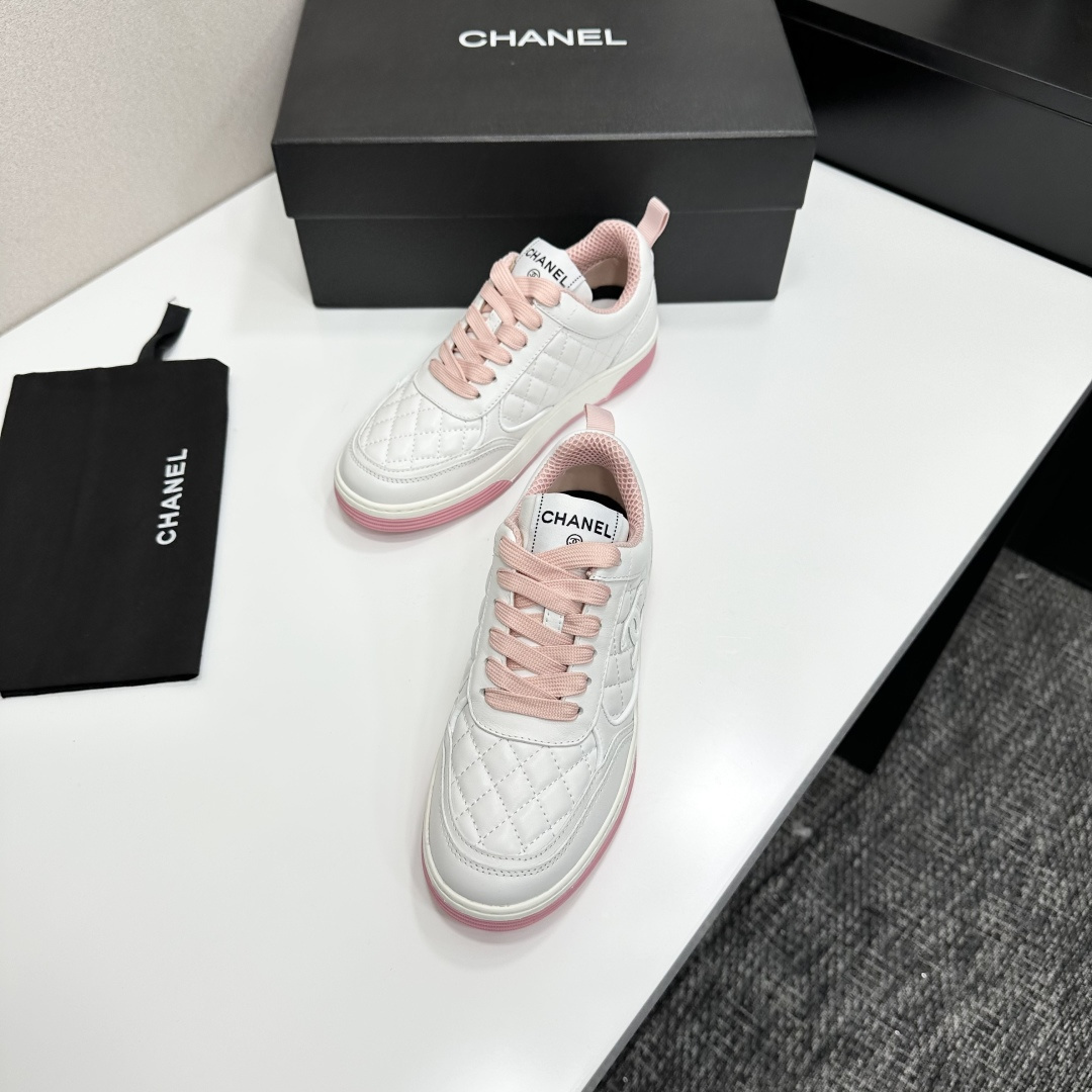 A pair of Chanel white quilted leather sneakers with pink laces and pink outsoles displayed on a black box. - Hình 7
