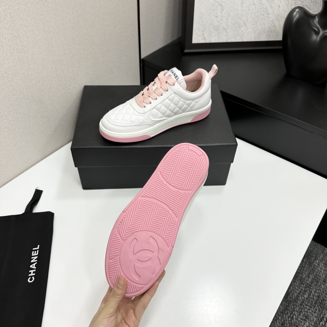 A pair of Chanel white quilted leather sneakers with pink laces and pink outsoles displayed on a black box. - Hình 6