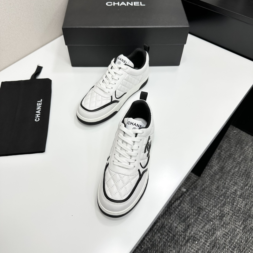 A pair of white quilted leather sneakers with black interlocking logo and trim displayed on a black box - Hình 6