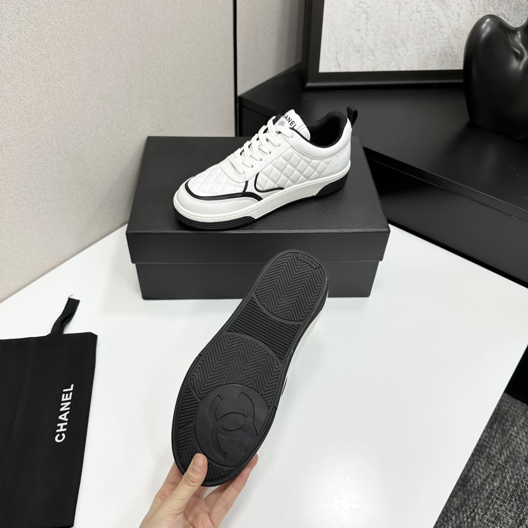 A pair of white quilted leather sneakers with black interlocking logo and trim displayed on a black box - Hình 5