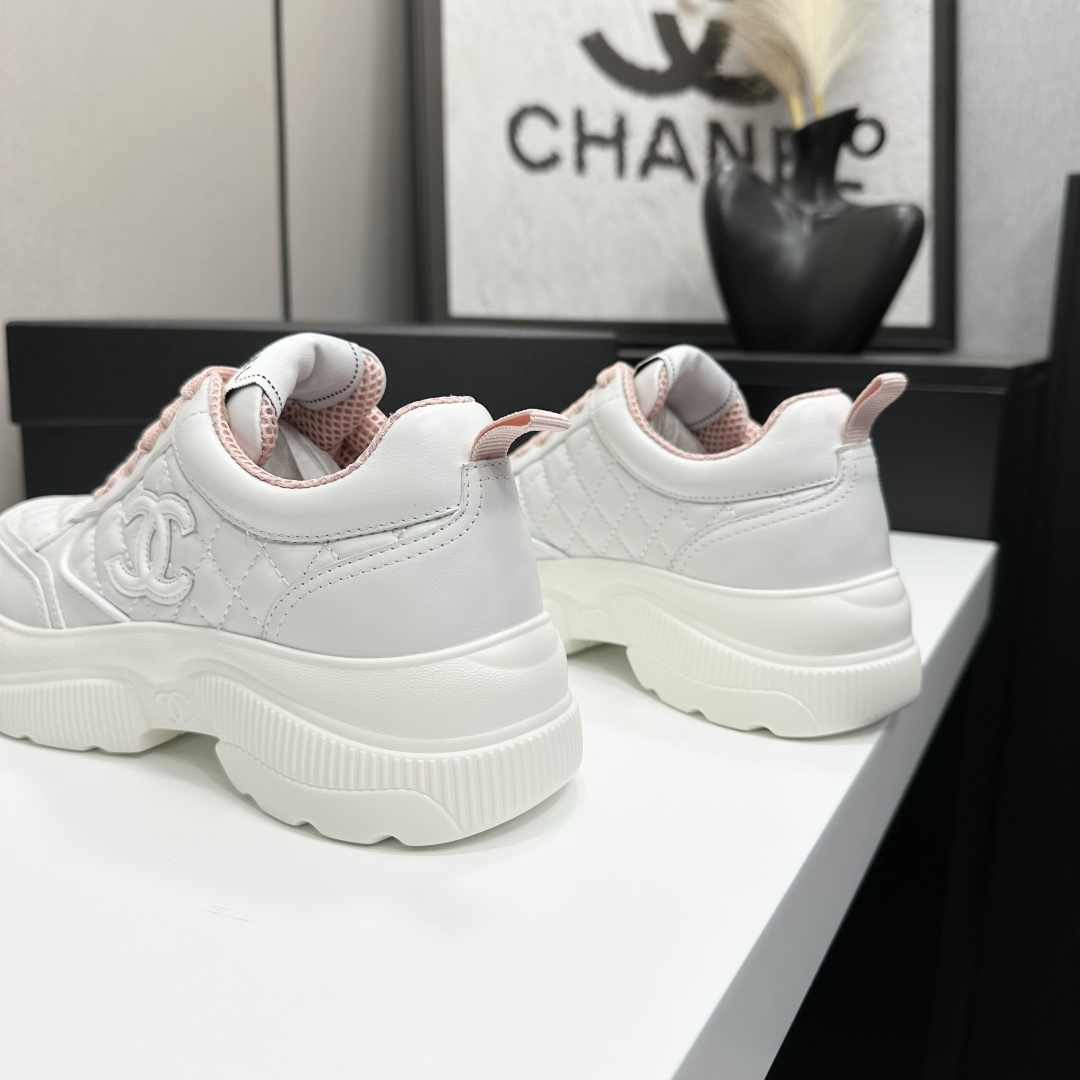 A pair of luxury Chanel white quilted platform sneakers with pink laces and pink interior lining displayed on a black box. - Hình 8