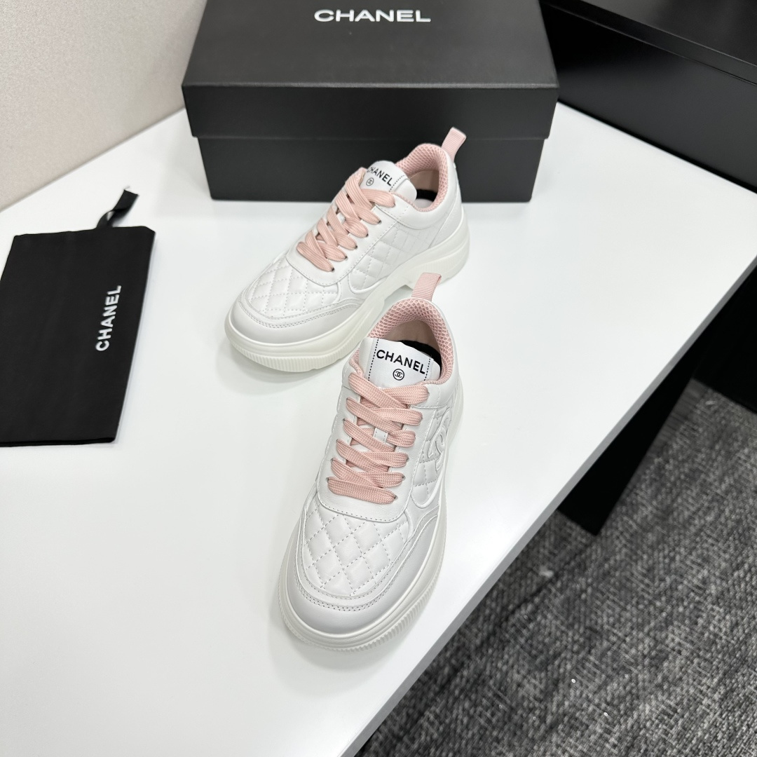 A pair of luxury Chanel white quilted platform sneakers with pink laces and pink interior lining displayed on a black box. - Hình 6