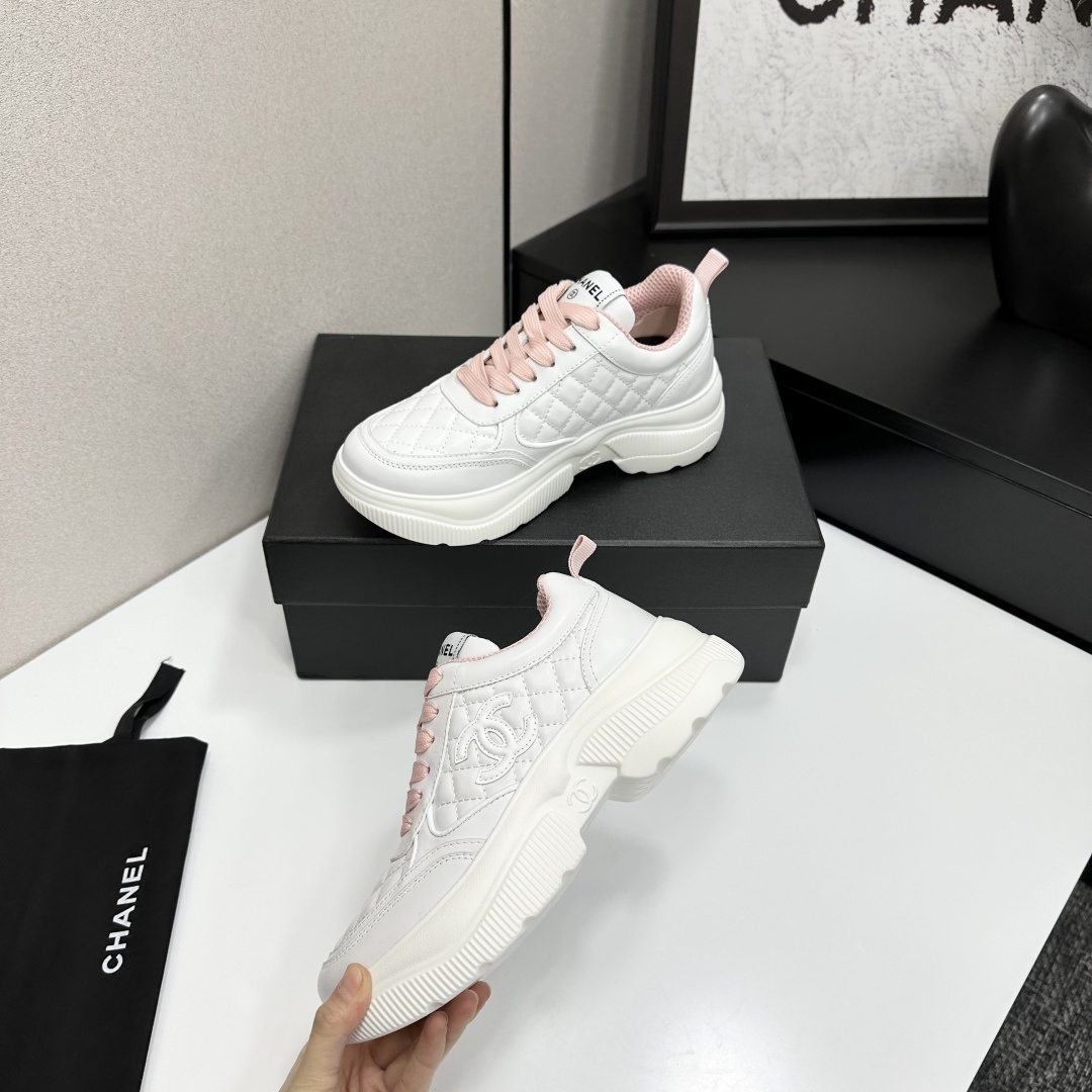 A pair of luxury Chanel white quilted platform sneakers with pink laces and pink interior lining displayed on a black box. - Hình 4
