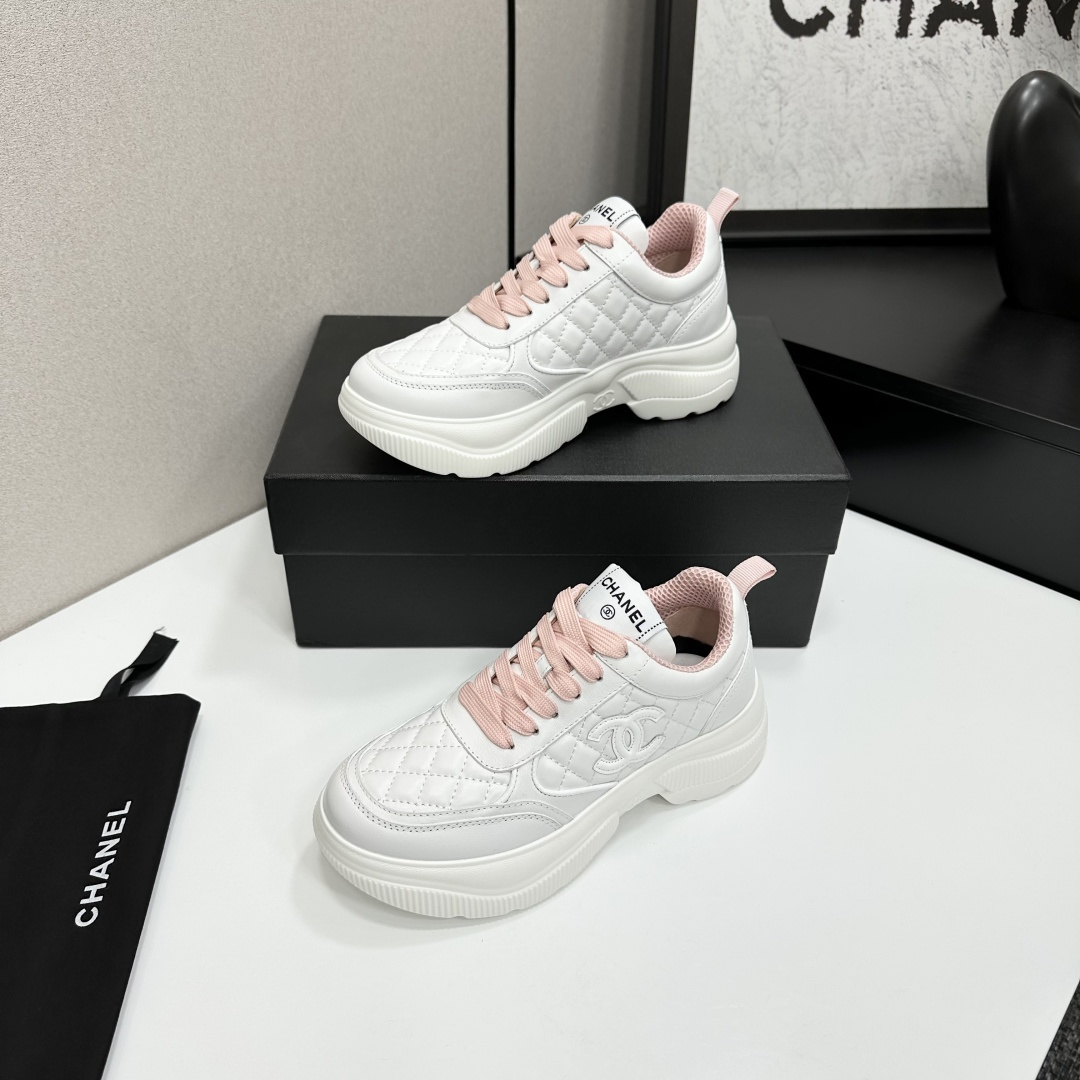 A pair of luxury Chanel white quilted platform sneakers with pink laces and pink interior lining displayed on a black box. - Hình 3