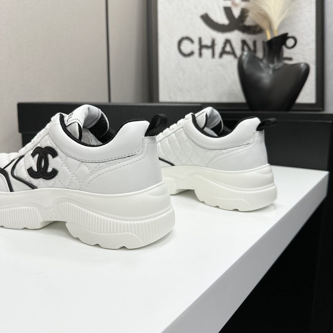 Side view of Chanel white quilted platform sneakers with black CC logo sitting on a branded black box. - Hình 8