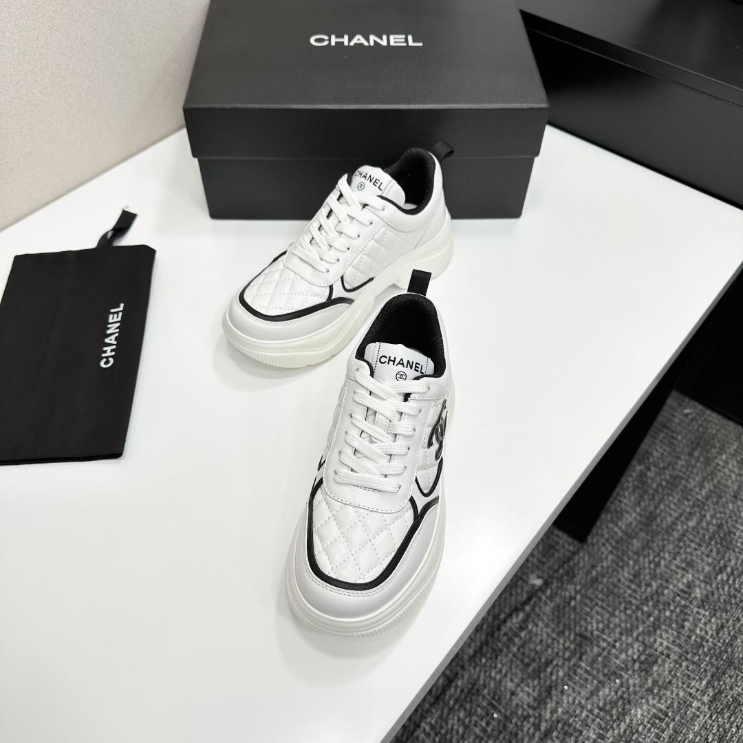 Side view of Chanel white quilted platform sneakers with black CC logo sitting on a branded black box. - Hình 6