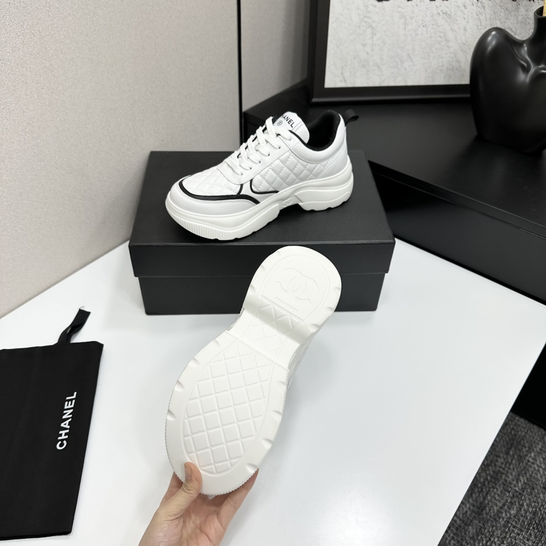 Side view of Chanel white quilted platform sneakers with black CC logo sitting on a branded black box. - Hình 5