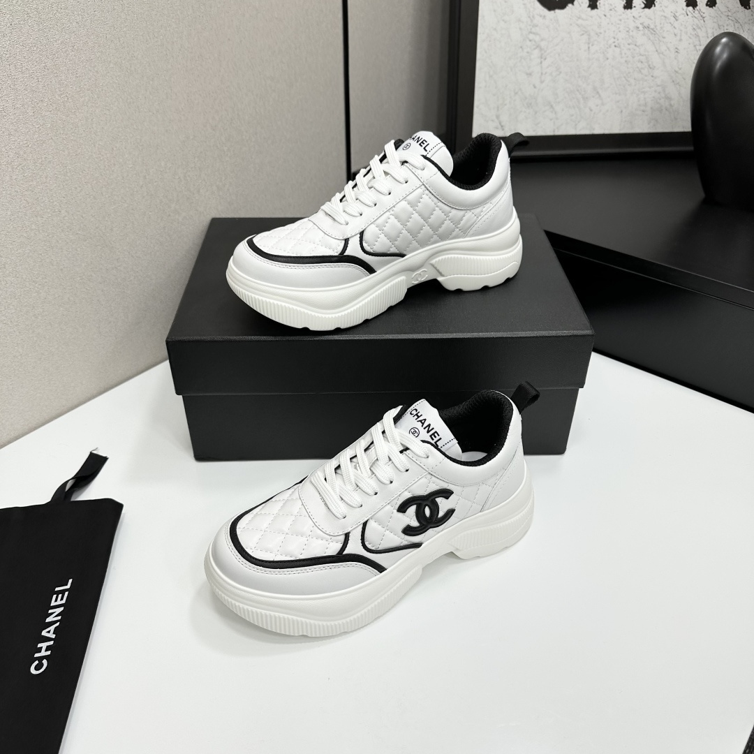 Side view of Chanel white quilted platform sneakers with black CC logo sitting on a branded black box. - Hình 3