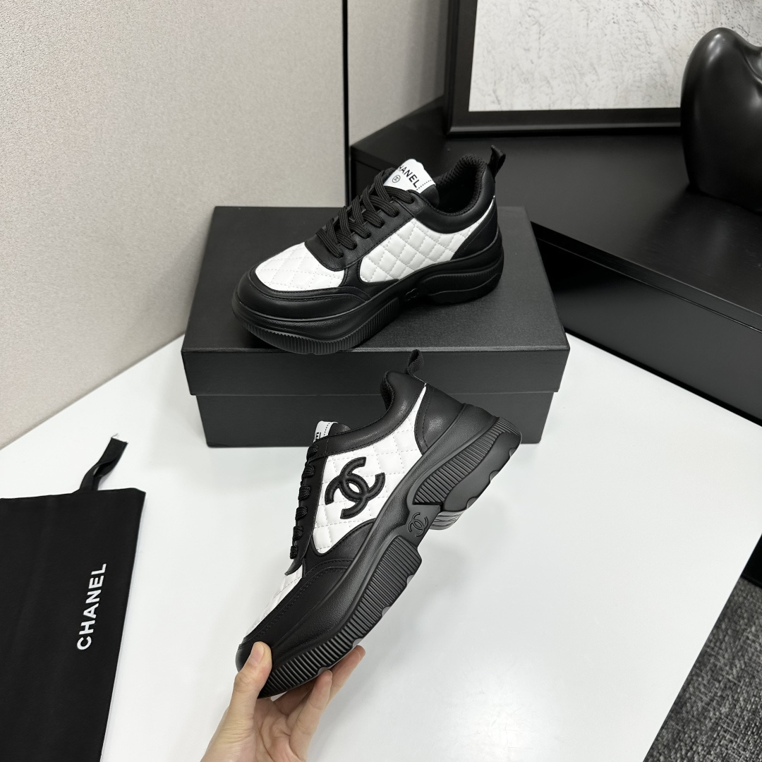 A pair of luxury Chanel black and white quilted leather sneakers with a chunky platform sole, displayed with original box and dust bag. - Hình 4