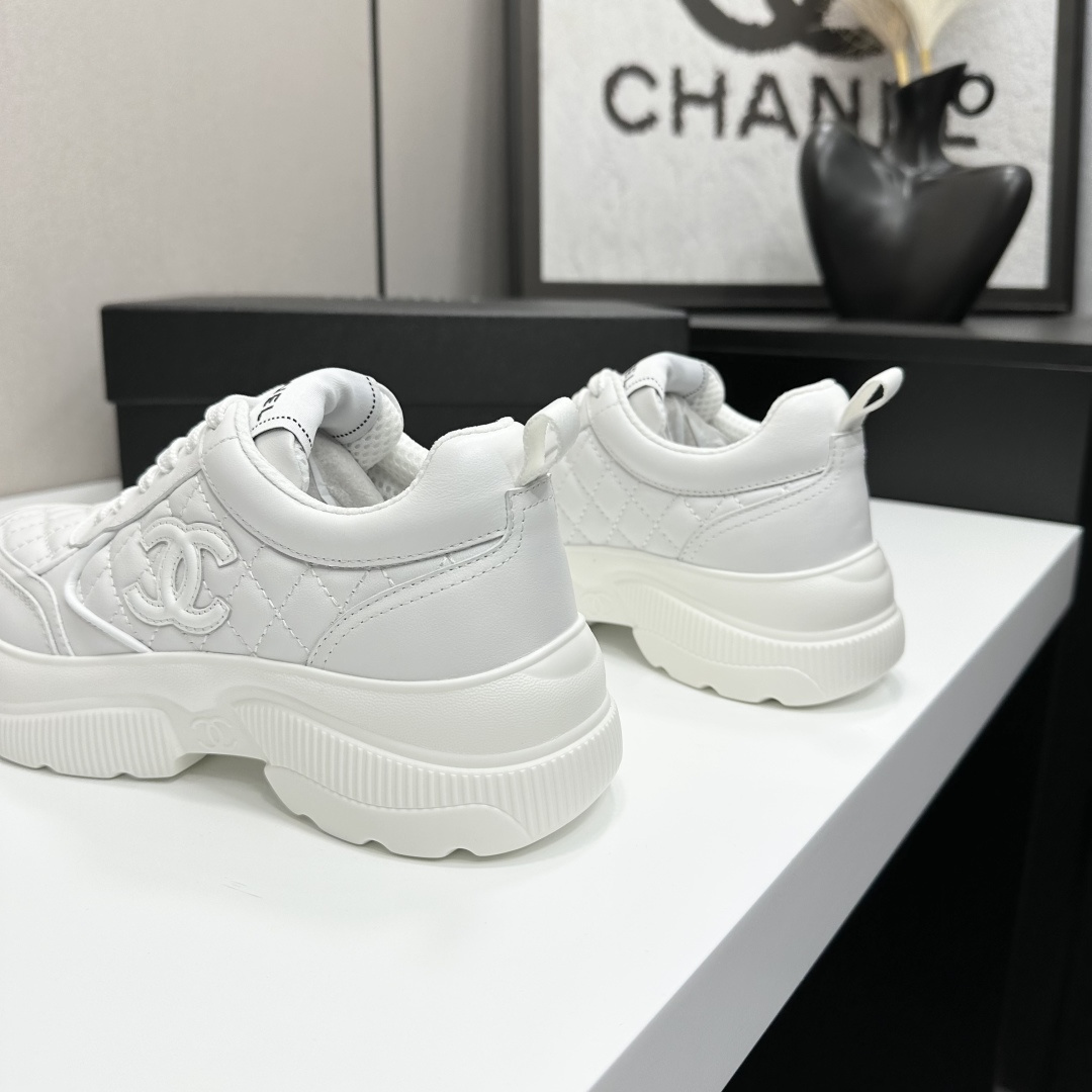 Side view of white Chanel quilted leather platform sneakers with interlocking C logo on a black display box - Hình 10