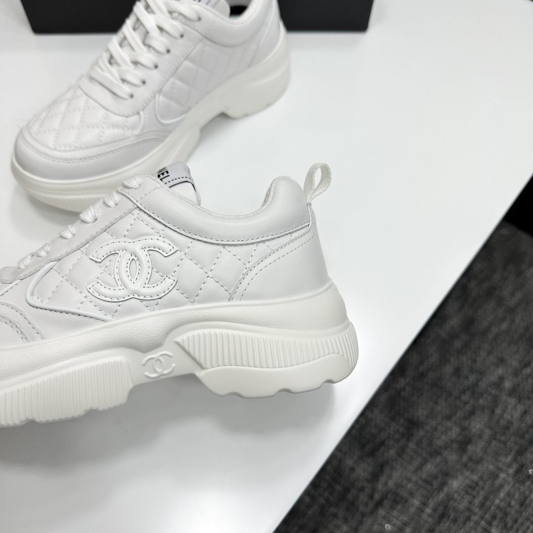 Side view of white Chanel quilted leather platform sneakers with interlocking C logo on a black display box - Hình 9