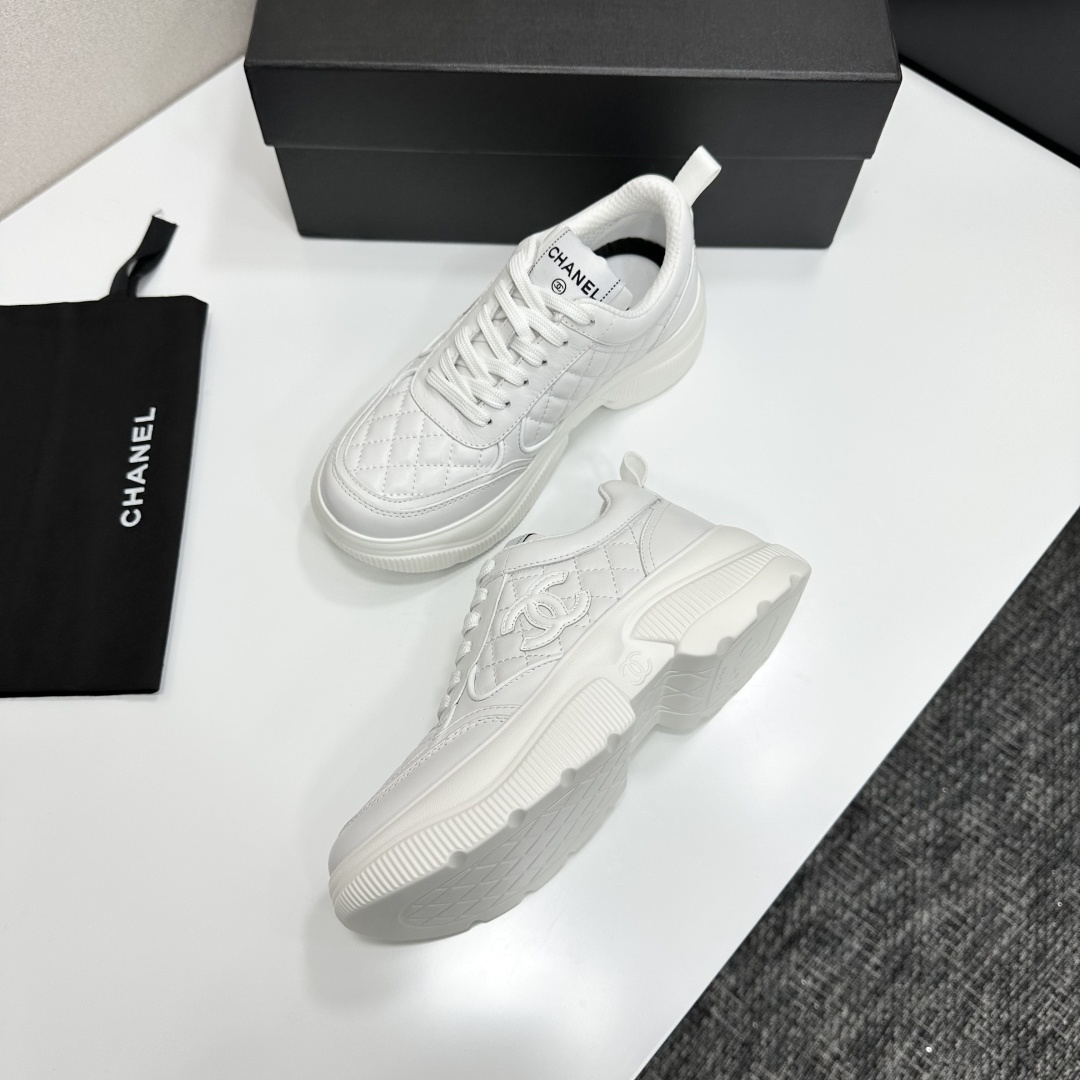 Side view of white Chanel quilted leather platform sneakers with interlocking C logo on a black display box - Hình 8