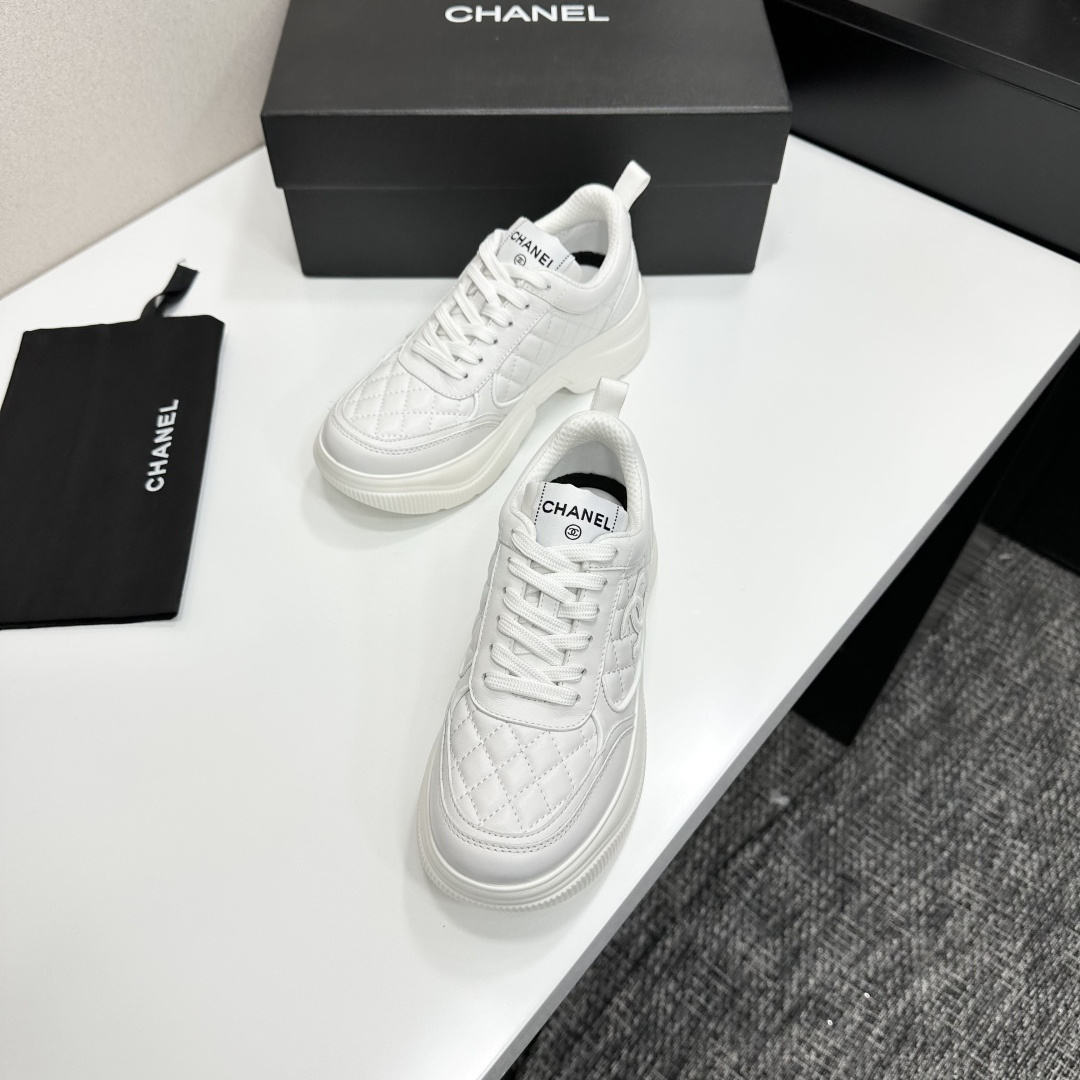 Side view of white Chanel quilted leather platform sneakers with interlocking C logo on a black display box - Hình 7