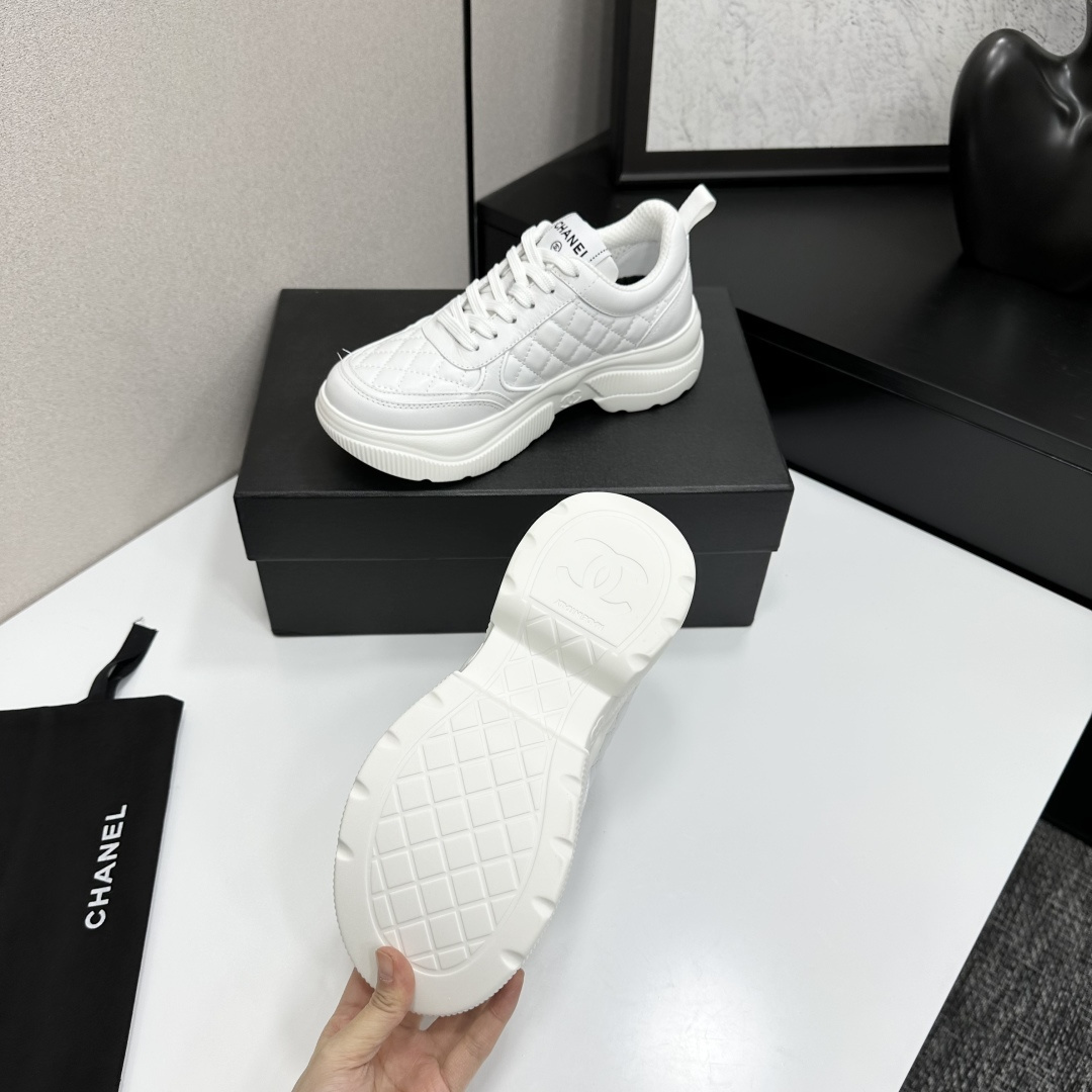 Side view of white Chanel quilted leather platform sneakers with interlocking C logo on a black display box - Hình 6