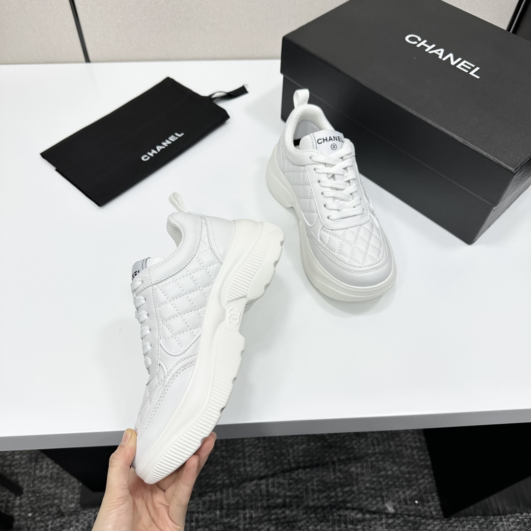 Side view of white Chanel quilted leather platform sneakers with interlocking C logo on a black display box - Hình 3