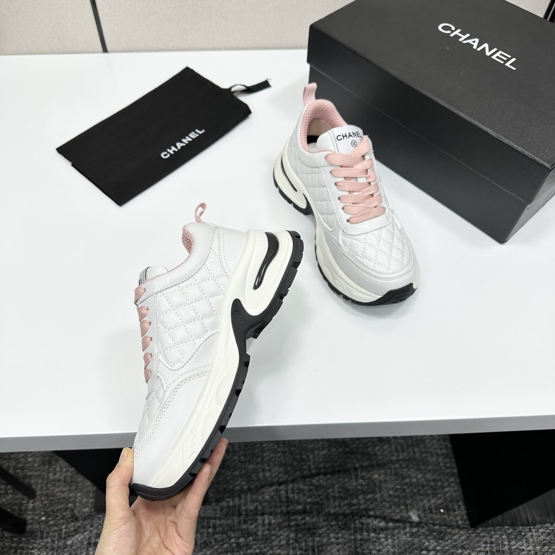 Pair of Chanel white quilted leather sneakers with pink laces and platform soles on a black box - Hình 10